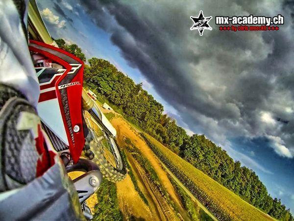 ATV riding? Motocross instead: camera view from a motorcycle of a red Honda leaning over, dark clouds above