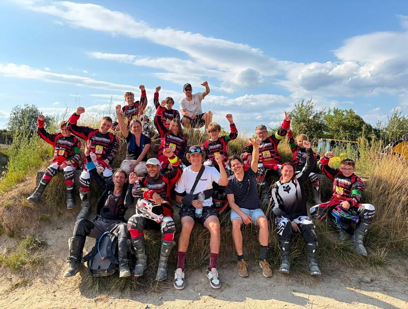 Contact MX-Academy: female and male riders in motocross gear standing together under the tent