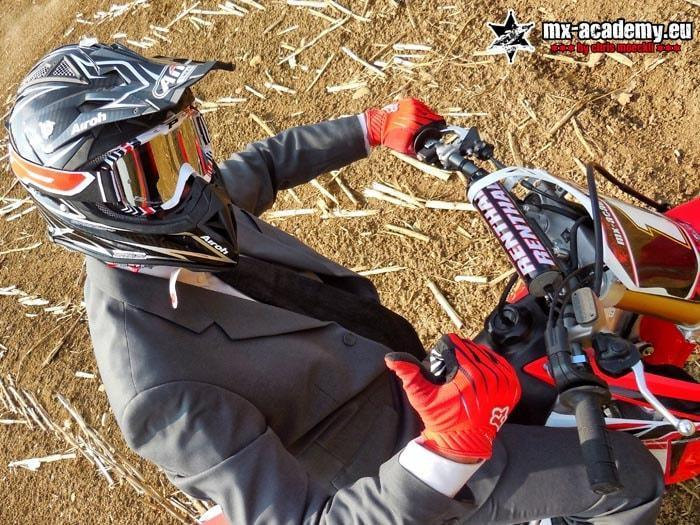 Corporate event idea with motocross: participant in helmet and goggles, both hands firmly on the handlebars