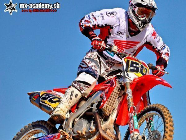 Dirt bike motorcycle from Honda: close-up of a rider with race number 150 against a blue sky