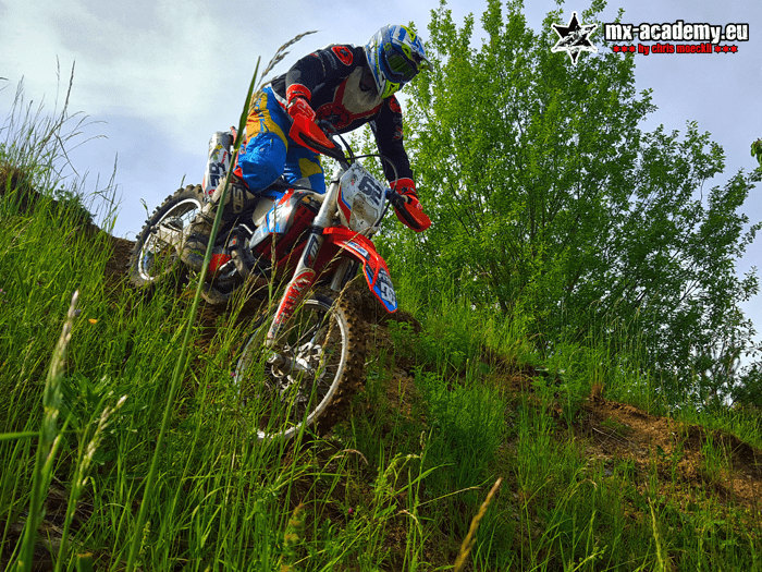 Enduro club: an enduro rider makes his way through tall grass on his motorcycle