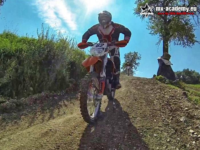Enduro club training: on a forest track, an enduro rider rides head-on towards the camera