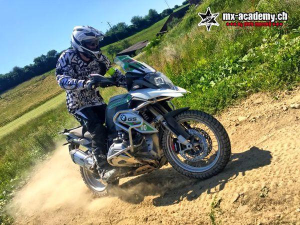 Enduro riding on a dusty farm track: a rider sits on a large adventure enduro bike