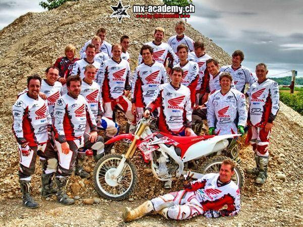 Event ideas for large groups: lots of people in Honda jerseys gathered around a Honda on a gravel mound