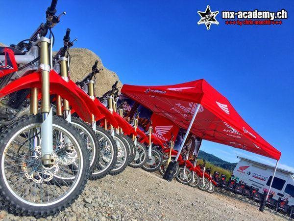 Events with motocross: a row of red Honda motorcycles next to the red Honda tent