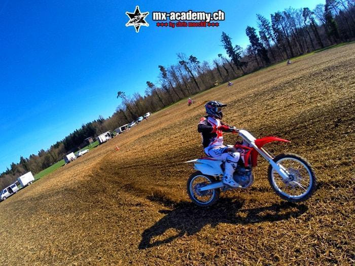 Flat track training: a rider leaning over on a flat dirt track, captured in a wide-angle shot