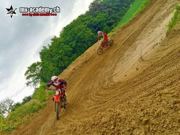 Freeride motorcycle technique: two riders on a steep sandy track, photographed from an oblique angle