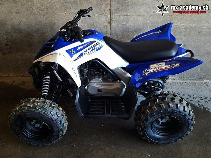 Kids quad in detail: a blue and white quad for children, parked inside a hall