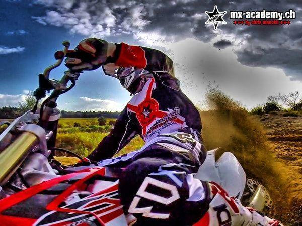Learn to drift from a first-person view: camera on the motorcycle, rider leaning over, earth spraying up