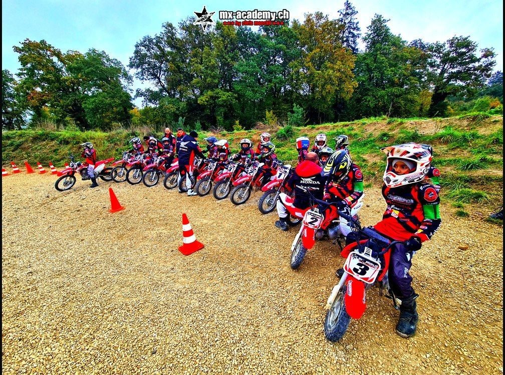 Mini motocross on the kids' track: several children riding their bikes between traffic cones