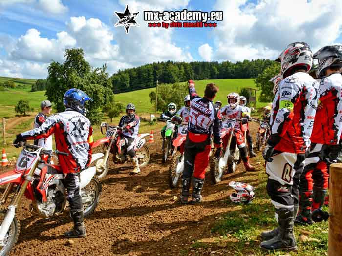 Motocross course for adults: a group of riders standing together with the coaches on the grounds