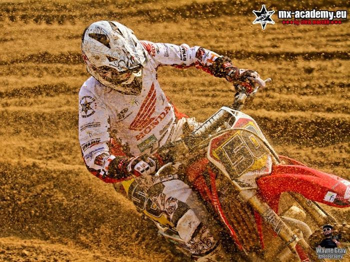 Motocross course questions: a rider on a Honda leans into the corner on the track