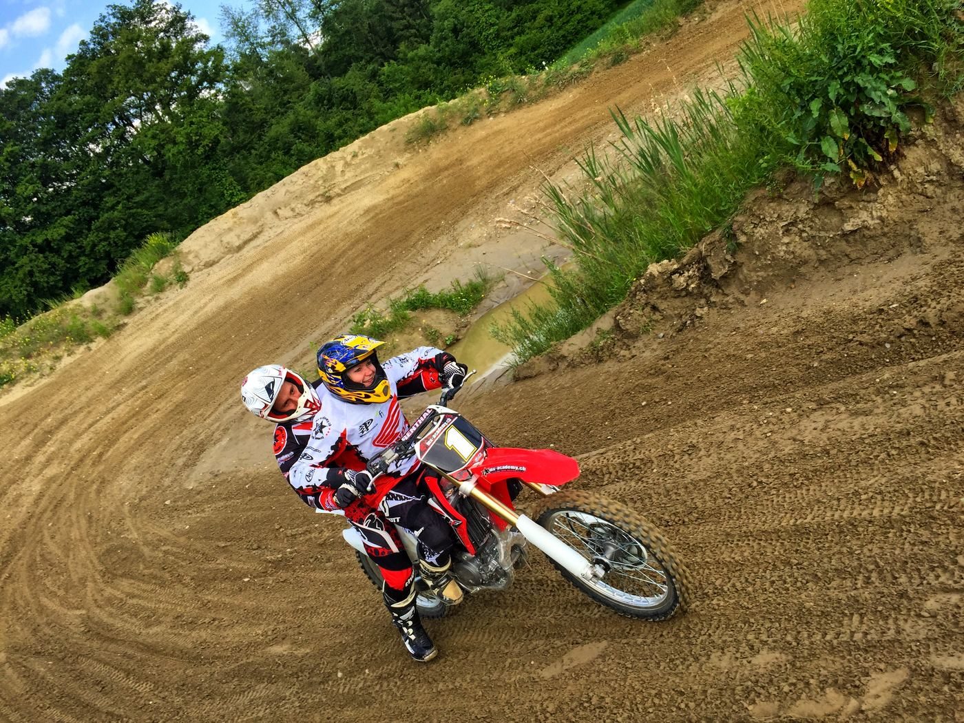 Motocross for women: a rider in full motocross gear leans into a banked corner