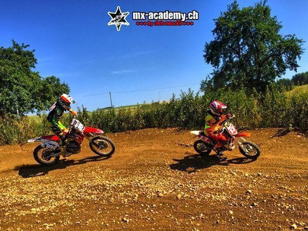 Motocross pictures: two children on kids' motorcycles riding through a dirt corner