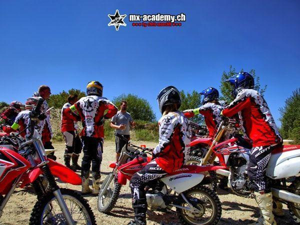 Motocross pictures: young riders standing together with their motorcycles for a briefing