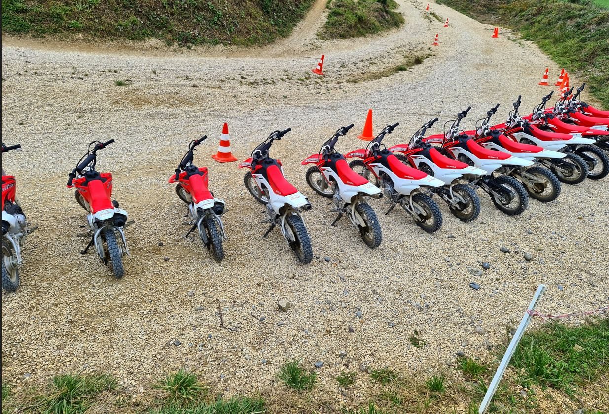 Motocross track with bike rental: red Honda rental bikes lined up by the cones on the training grounds