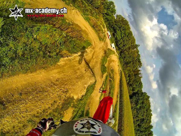 Motocross tracks seen from a helmet camera: view over the motorcycle onto the winding motocross track