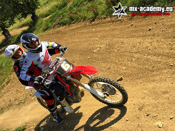 Motorcycle course for beginners: a newcomer rides his motorcycle through a bend out in the terrain