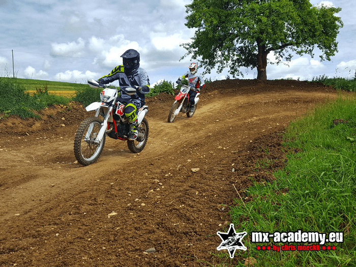 Motorcycle training for beginners: two riders out on their motorcycles on a track through the fields