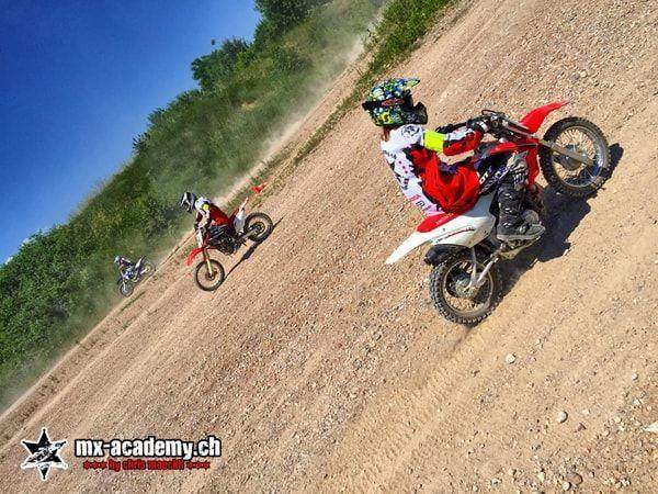 Motorsport weekend as a group: three riders in a row in the dust, led by a child in a colourful helmet