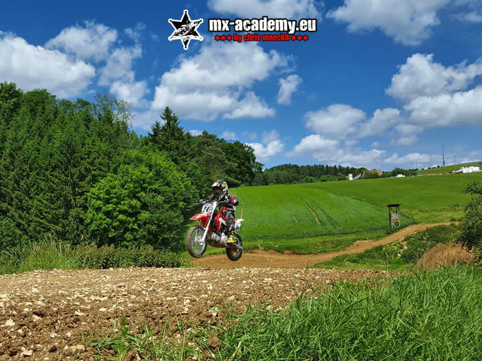 MX club training: a single rider on his motocross bike in the middle of the green track