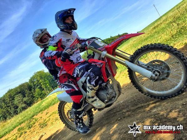 MX photos: Honda with two people on board on a slope, the front wheel coming up