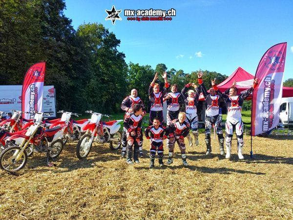 MX photos: young and old jump into the air cheering, motorcycles and a tent behind them