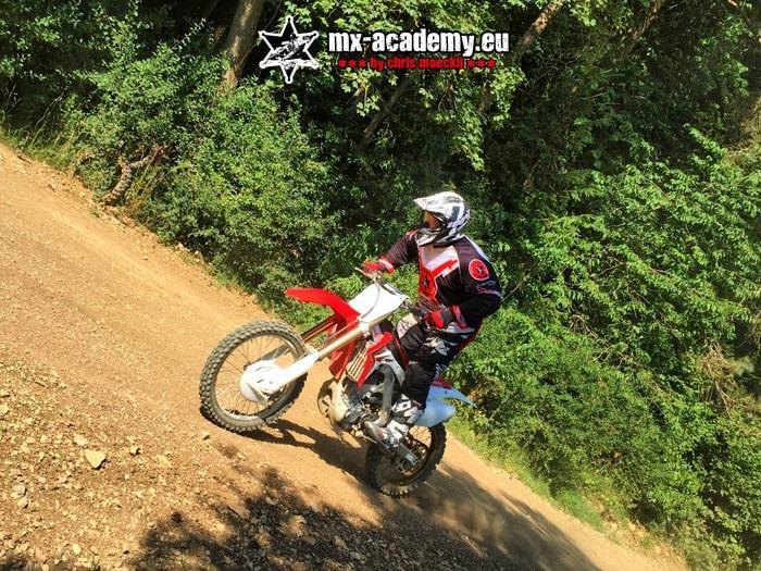Off-road adventure on a motocross bike: a rider works his way along a wooded slope