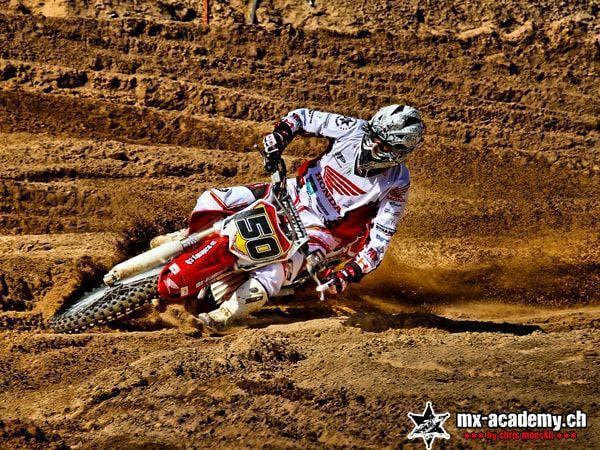 Off-road motorbike: rider with race number 50 in a deeply rutted corner full of grooves in the ground