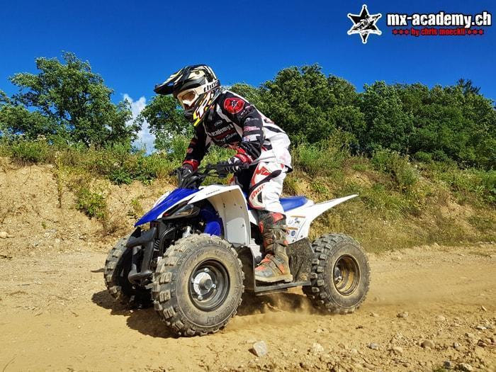 Quad and ATV riding: a young rider is out and about in the terrain on a blue quad