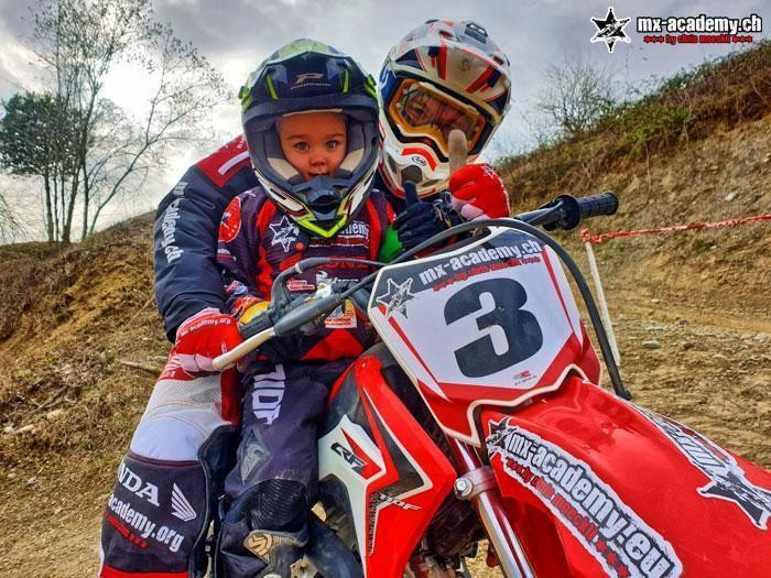 Quad for kids? Kids motocross instead: a child with race number 3 sits on a motocross bike, the coach behind him