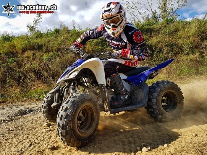 Quad riding and ATV riding off-road: a quad rider on the move, with dust flying up all around