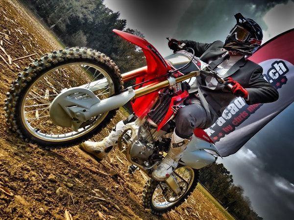 Staff outing with a difference: rider in a suit and tie on a red Honda next to a flag