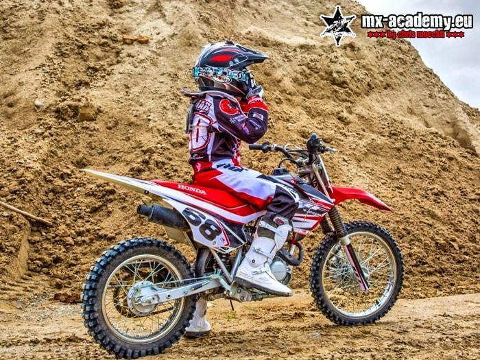Teen motocross in the sand: a young rider steers his Honda through the deep sand