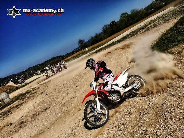 Weekend with motocross: a cloud of dust behind a rider in a corner, with more riders waiting behind