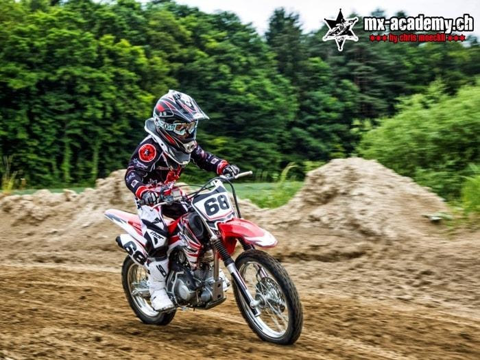 Youth motocross on the track: a young rider with race number 68 on his motocross bike
