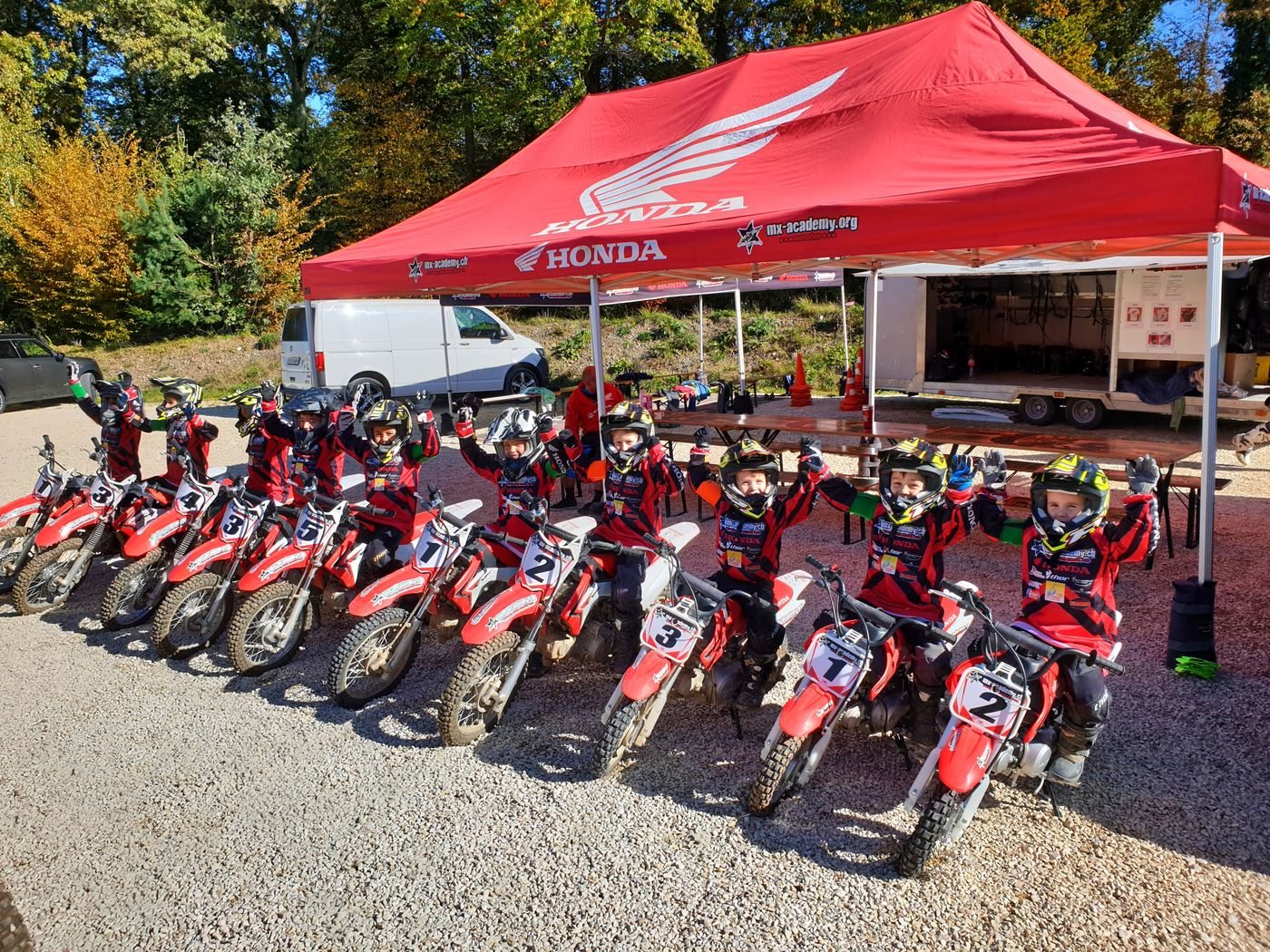 Firmenevents mit Motocross: Honda-Zelt und aufgereihte Motocross-Motorräder für die Gruppe